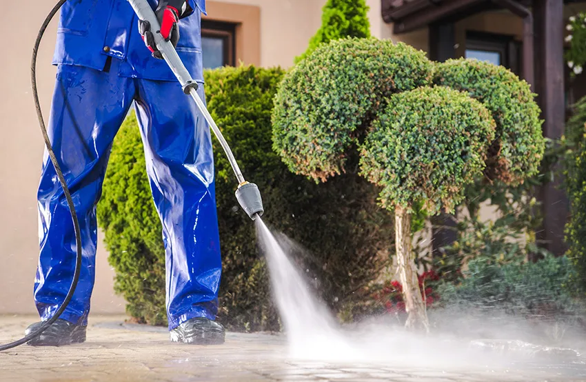 A man pressure washing concrete.