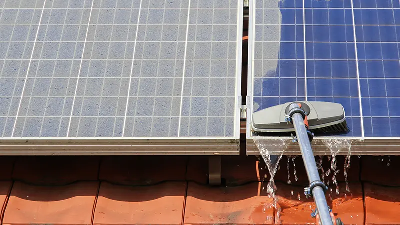 A brush cleaning a solar panel.