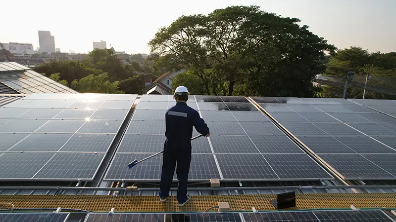 A person cleaning a solar panel.