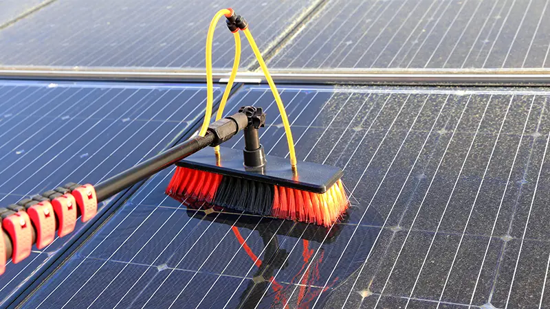 A brush cleaning a solar panel.