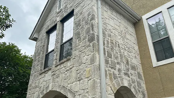 Dirty brick siding, before a house wash.