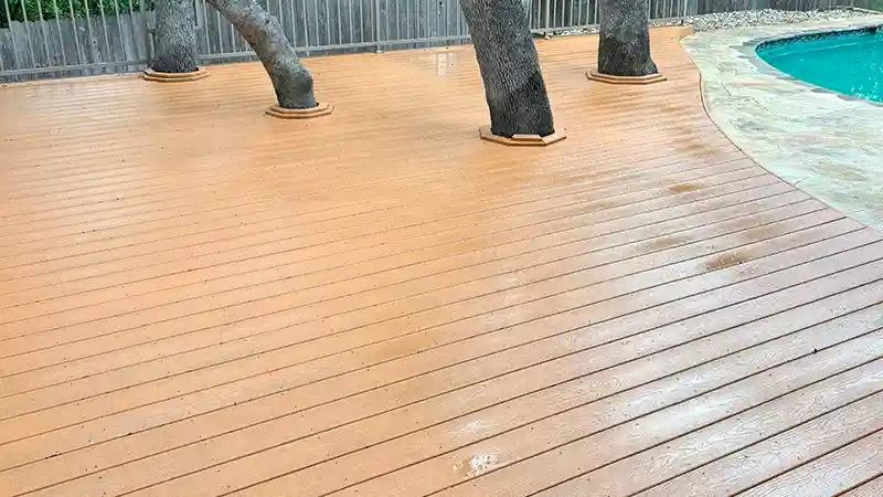 A clean composite deck beside a pool.