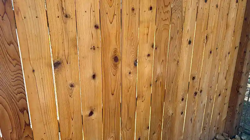 A wooden fence that has been brightened with a wood brightener.