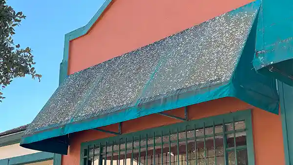 A dirty awning covered in mold, mildew, and lichen.