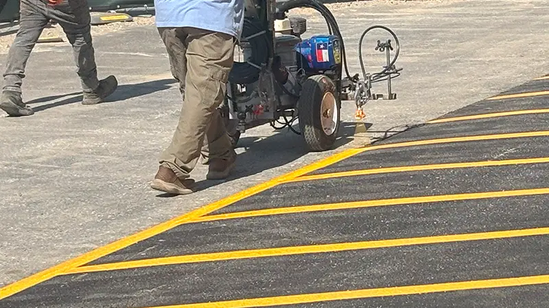 Yellow lines being painted on new asphalt.