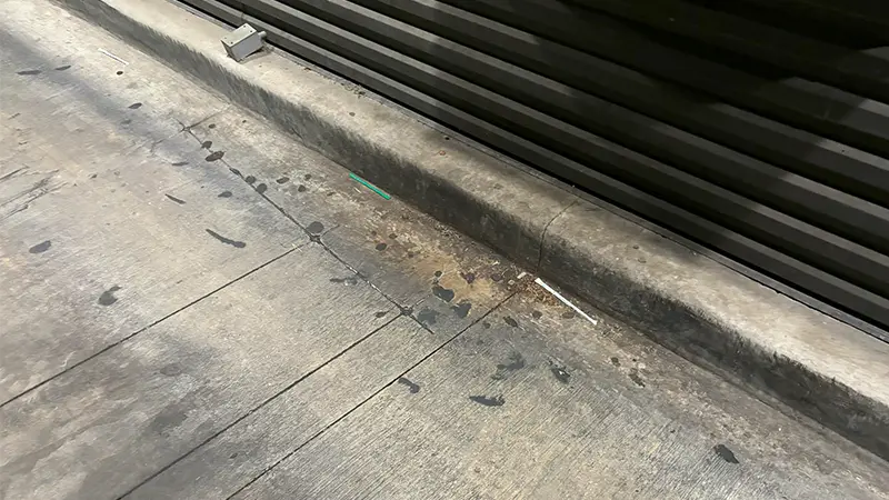 Dirty concrete below a drive-thru window.