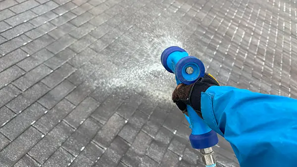 A shingle roof getting cleaned.