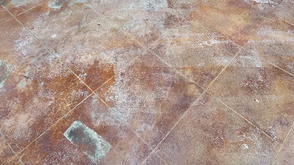 A decorative concrete patio in San Antonio with a white and failing sealer.